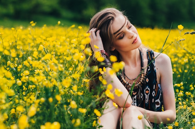 hermosa niña en un campo de flores amarillas