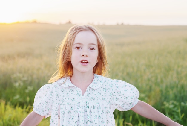 Hermosa niña en el campo de fondo al atardecer