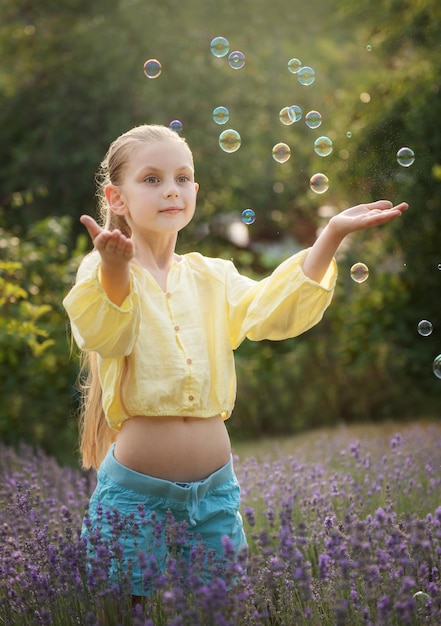 Hermosa niña en un campo con lavanda