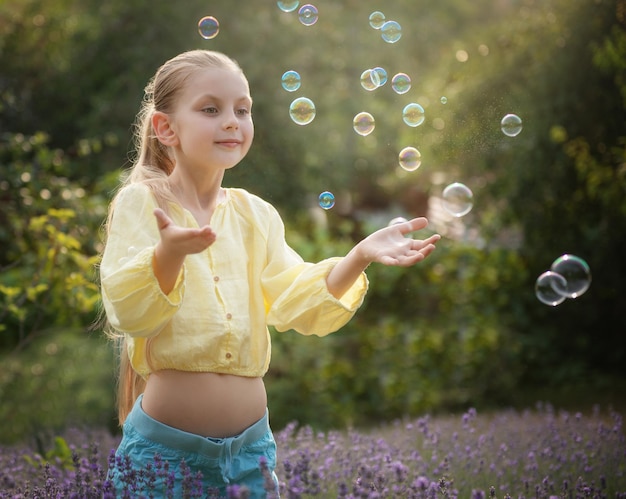 Hermosa niña en un campo con lavanda