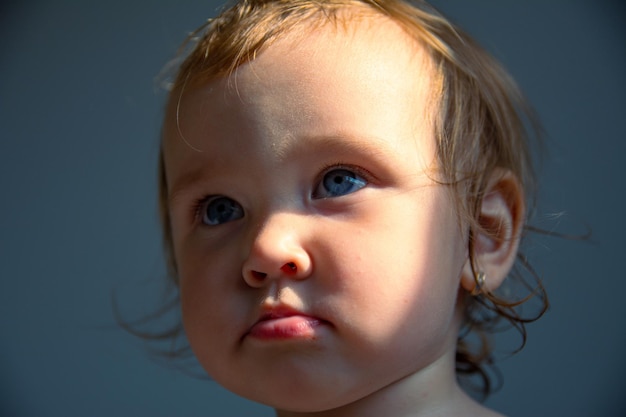 Una hermosa niña caucásica mira seriamente el marco con ojos grandes. Retrato de un niño.