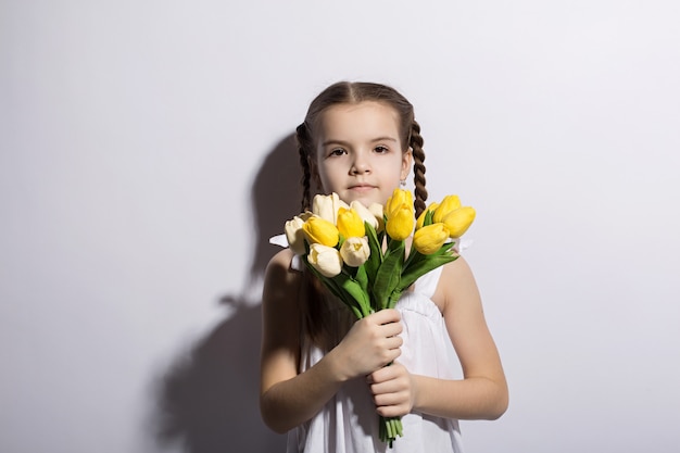 Hermosa niña caucásica con un ramo de tulipanes