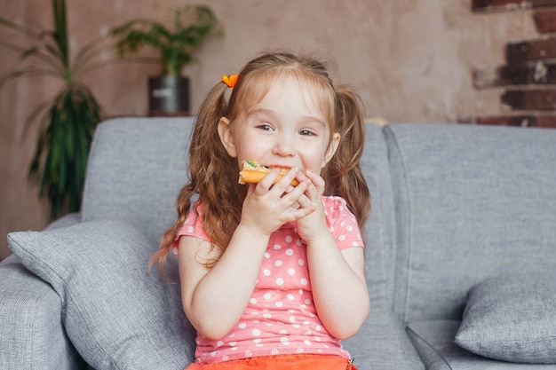 Foto hermosa niña comiendo pizza en casa