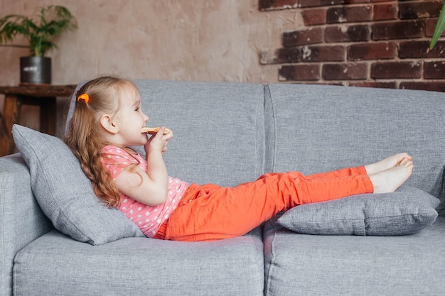 Hermosa niña comiendo pizza en casa