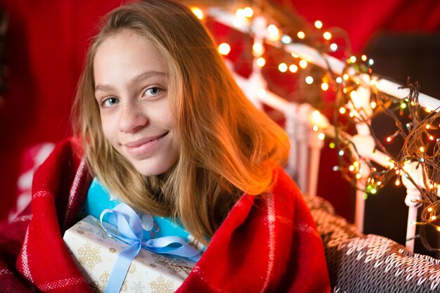 Hermosa niña de unos diez años, posando para un fotógrafo en un interior de Navidad