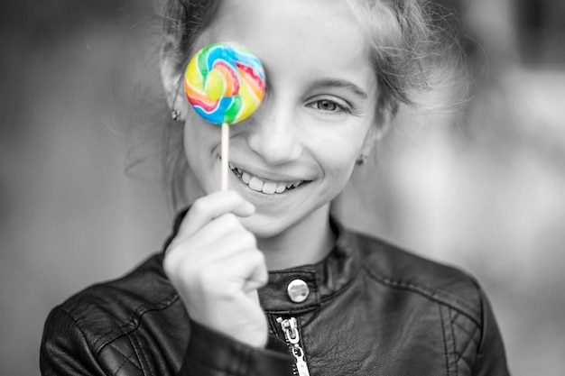 Hermosa niña con dulces al aire libre