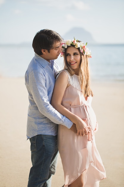 Hermosa niña embarazada y hombre en la playa