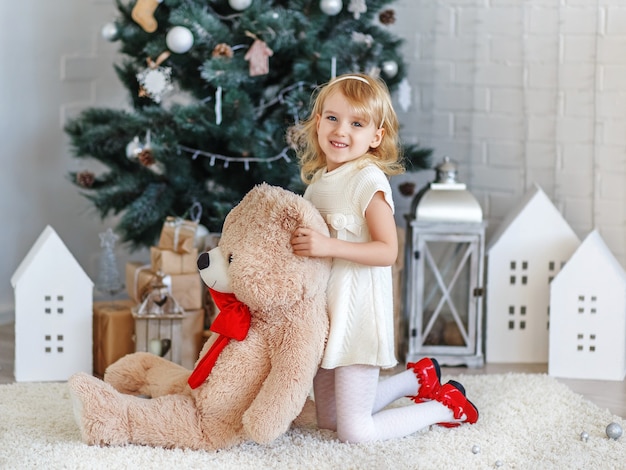 Hermosa niña esperando un milagro en adornos navideños