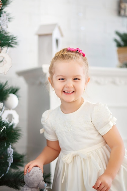 Hermosa niña esperando un milagro en adornos navideños