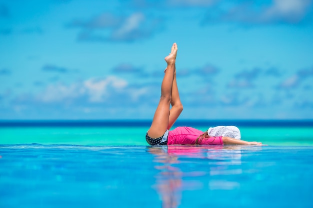 Foto hermosa niña feliz divirtiéndose en la piscina al aire libre