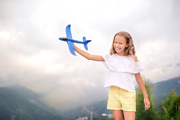 Hermosa niña feliz en las montañas en el fondo de niebla