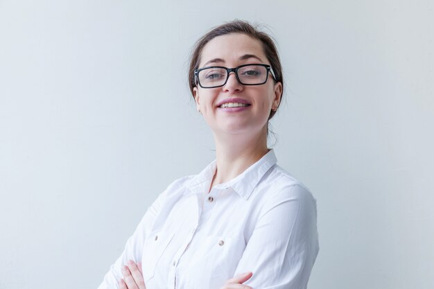 Hermosa niña feliz sonriendo. Belleza simple retrato joven sonriente mujer morena en las lentes aisladas sobre fondo blanco. Emoción humana positiva expresión facial lenguaje corporal. Copia espacio