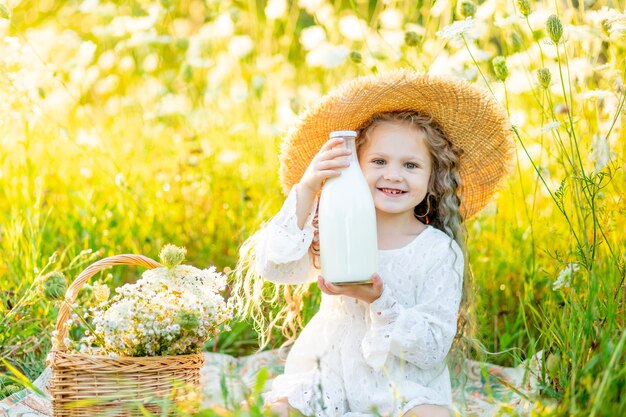 Hermosa niña con gafas de sol en un campo amarillo con flores en un tocadiscos