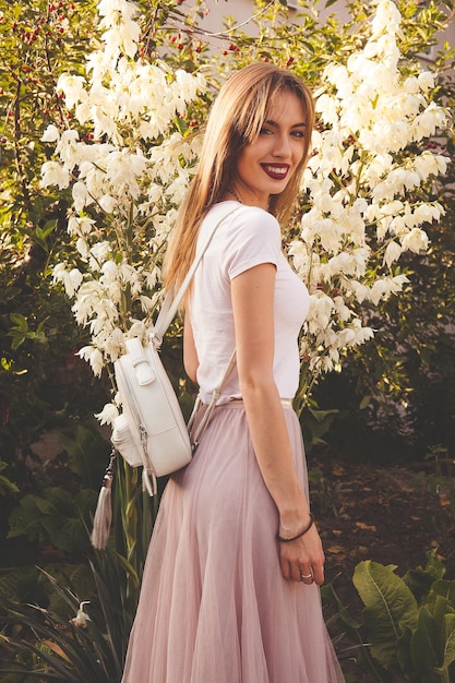 Hermosa niña en el jardín con flores