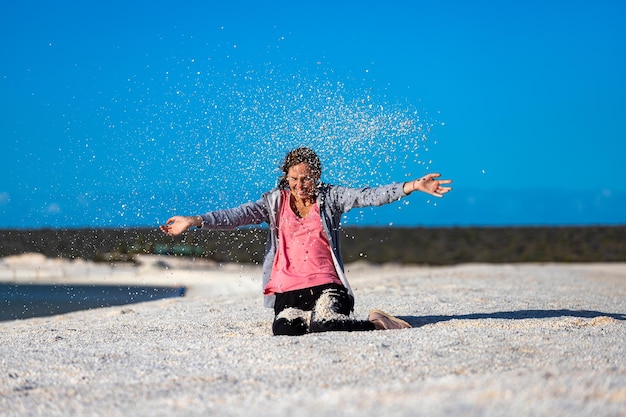 Una hermosa niña juega con conchas marinas en la famosa playa de conchas en el oeste de australia al atardecer