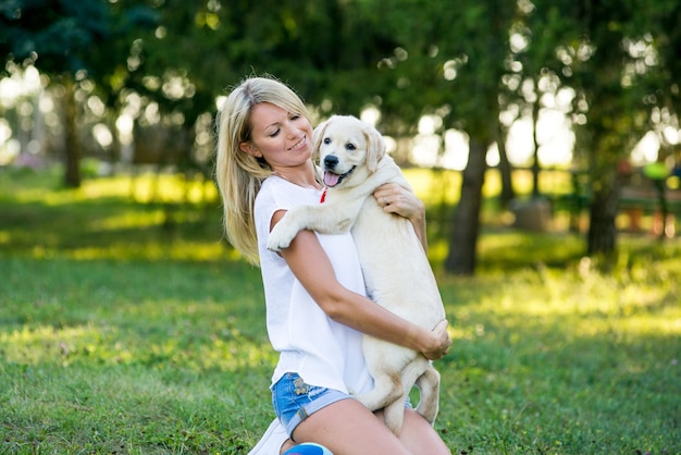 Hermosa niña jugando con un cachorro labrador