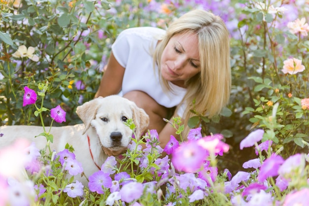 Hermosa niña jugando con un cachorro labrador