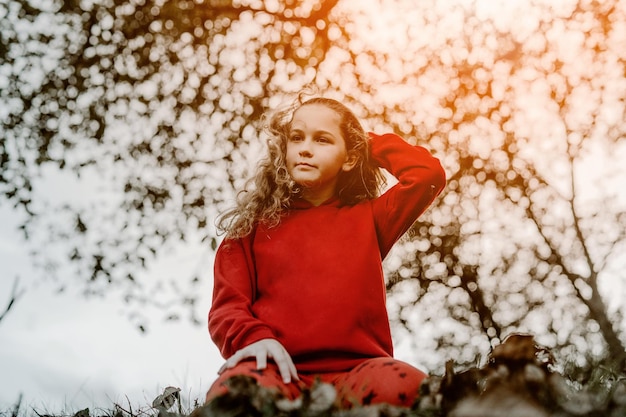 Una hermosa niña jugando en las hojas en otoño.