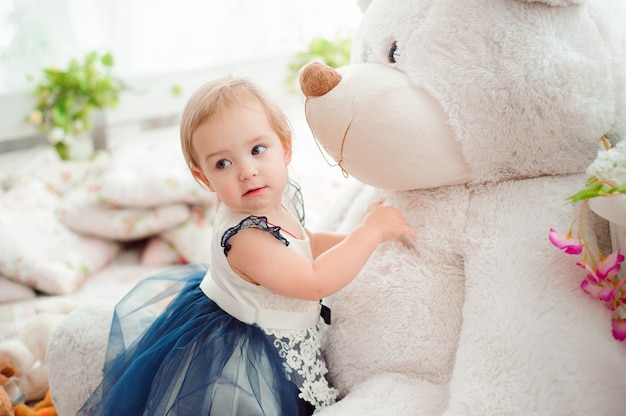 Hermosa niña con juguete sonriendo a la cámara