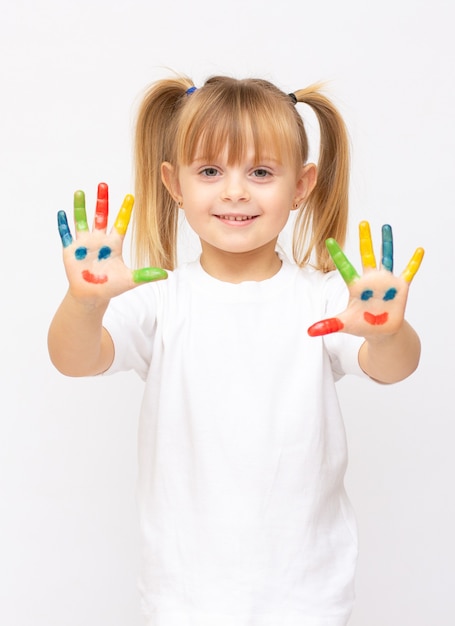 Hermosa niña con las manos en la pintura