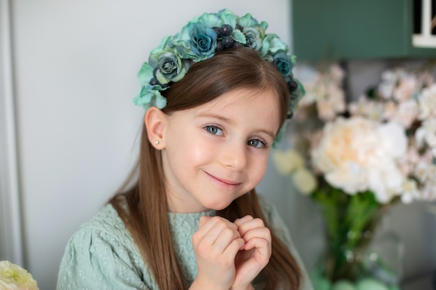 Hermosa niña mirando a puerta cerrada con una suave sonrisa haciendo gestos de corazón con las manos