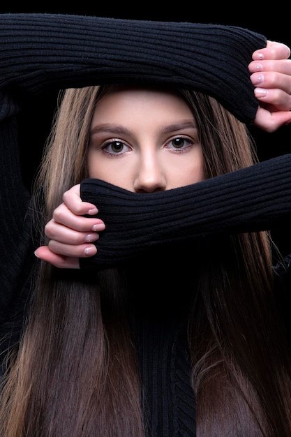 Una hermosa niña morena se cubrió la cara con las manos, dejando solo los ojos.