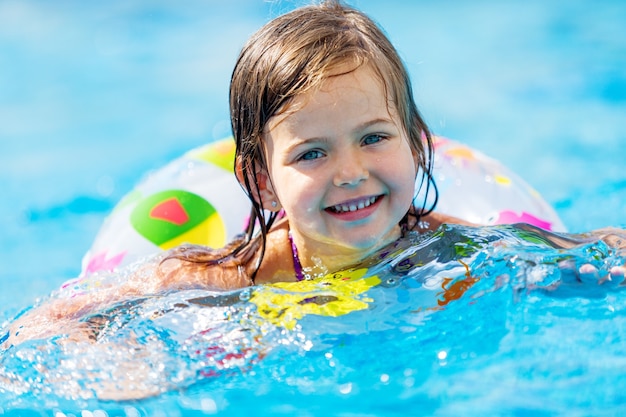 Hermosa niña nadando en la piscina