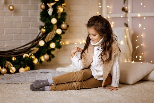 Hermosa niña niño sentado en la habitación