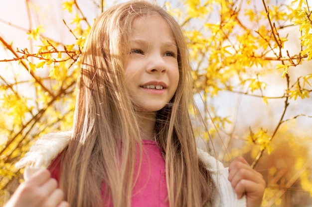 Hermosa niña en el parque en primavera.