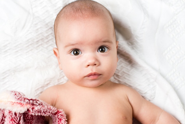 Hermosa niña pequeña feliz tumbado en la cama