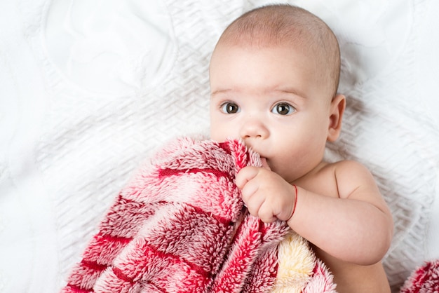 Hermosa niña pequeña feliz tumbado en la cama