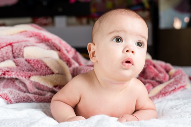 Hermosa niña pequeña feliz tumbado en la cama