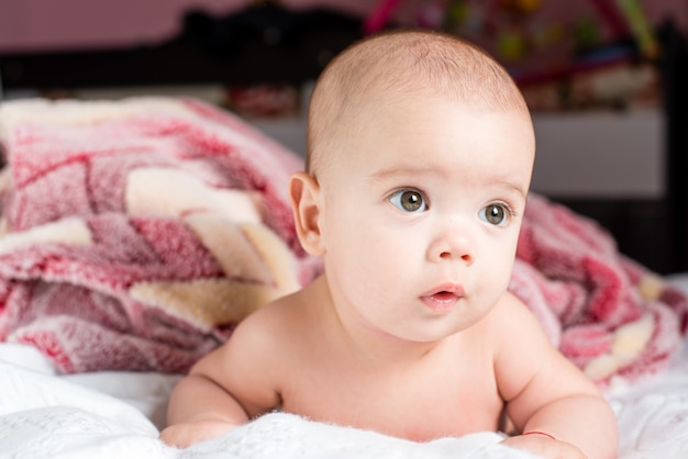 Hermosa niña pequeña feliz tumbado en la cama