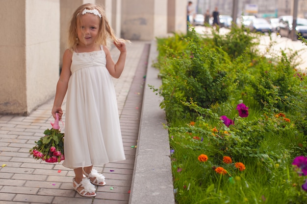 Hermosa niña con ramo de rosas en la mano en la boda