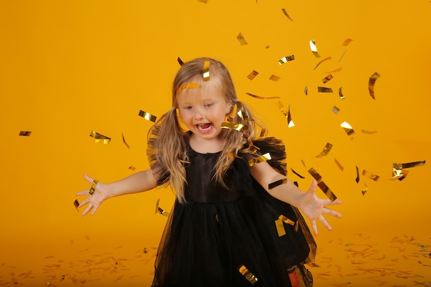 hermosa niña rubia con un vestido negro de halloween