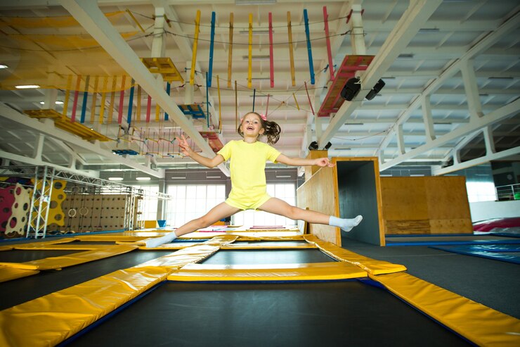 Hermosa niña saltando sobre un trampolín en un club de juegos