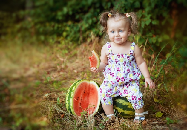 Hermosa niña sentada en una sandía. estilo de vida y alimentación saludable.