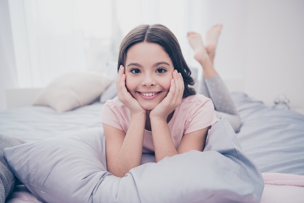 Hermosa niña sentada en su cama