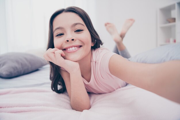 Hermosa niña sentada en su cama