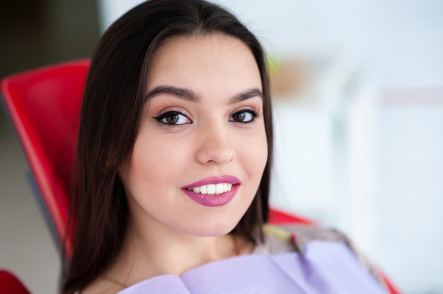 Hermosa niña sonriendo en la silla dental