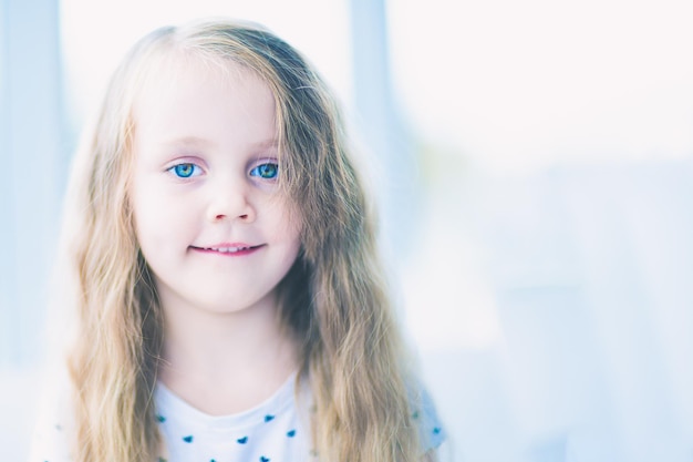 Hermosa niña sonriente con cabello largo y rubio