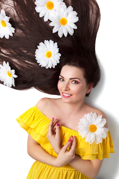 Hermosa niña sonriente con Camomiles en cabello largo