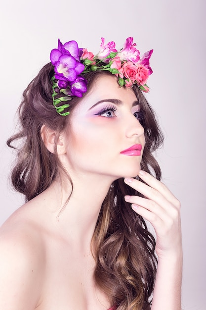 Hermosa niña sonriente con flores en el pelo