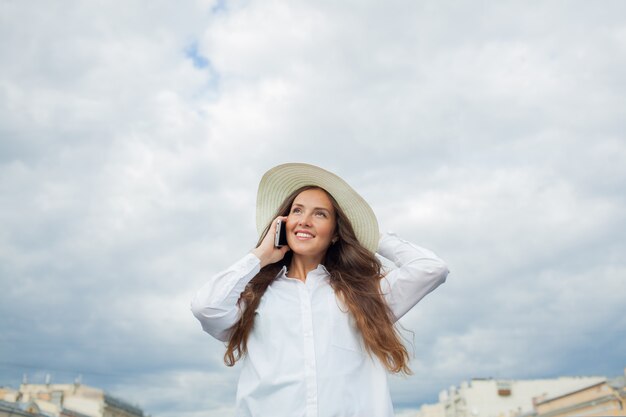 Hermosa niña sonriente hablando por teléfono.