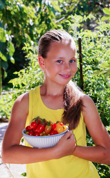 hermosa niña sonriente en el jardín recogiendo