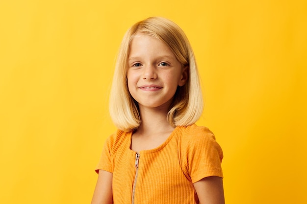 Hermosa niña sonrisa gestos con las manos posando ropa casual diversión fondo amarillo inalterado