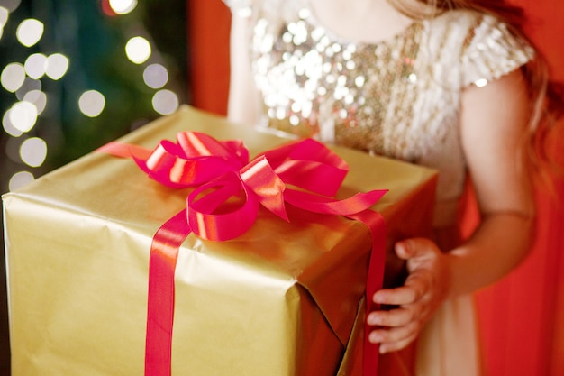 Hermosa niña sosteniendo una caja de regalo de Navidad. Celebración de Navidad y año nuevo.