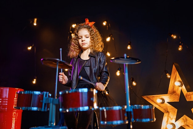 Hermosa niña tocando la batería