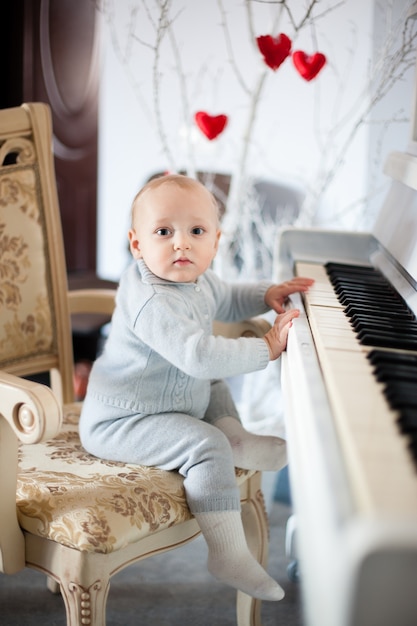 Hermosa niña tocando el piano en la sala de luz