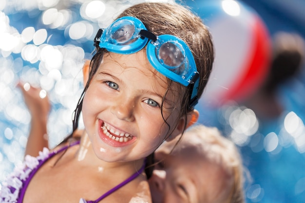 Hermosa niña tomando el sol en la piscina